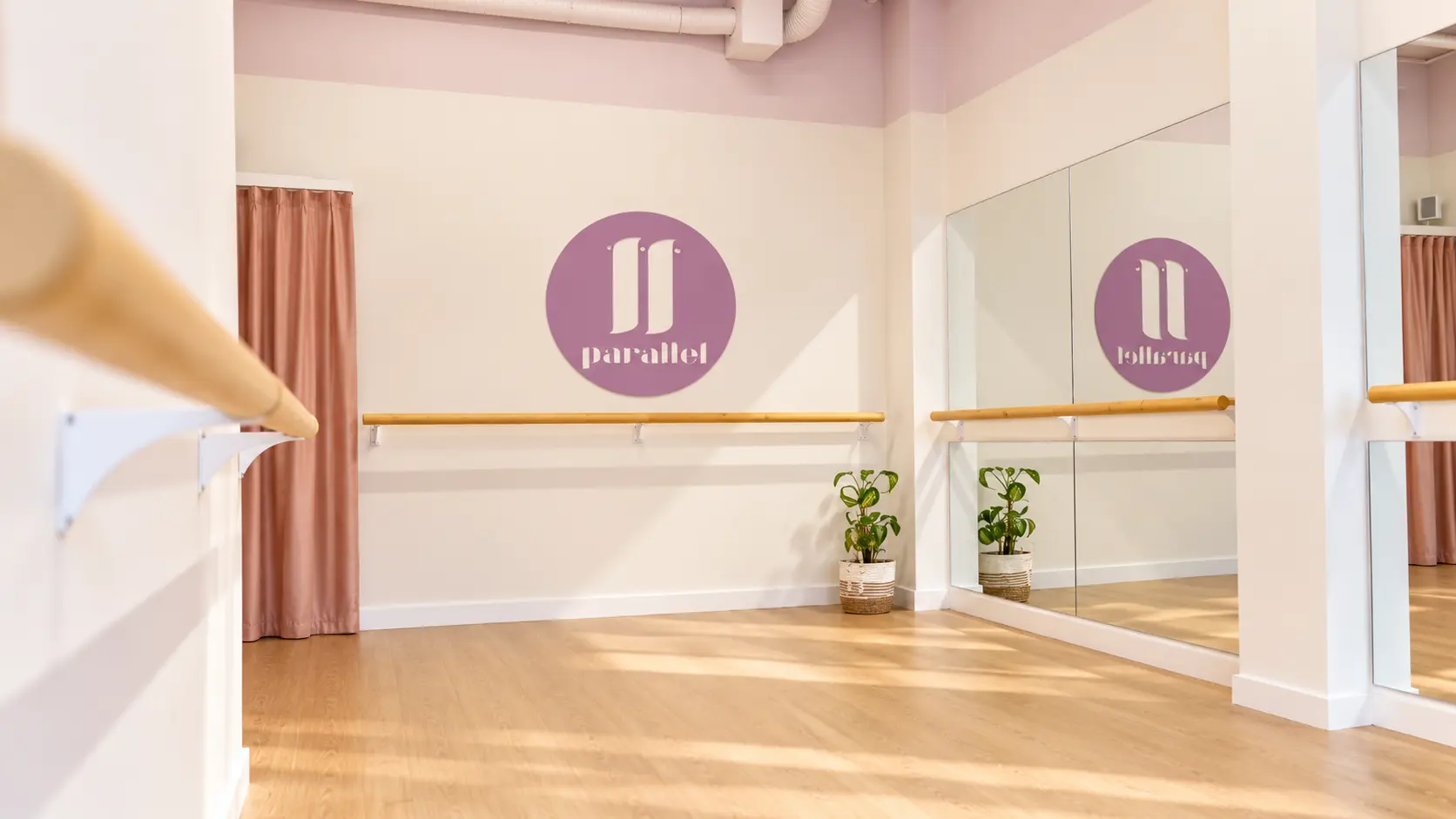 el aula de una clase de barre con el logo de parallel en la pared.